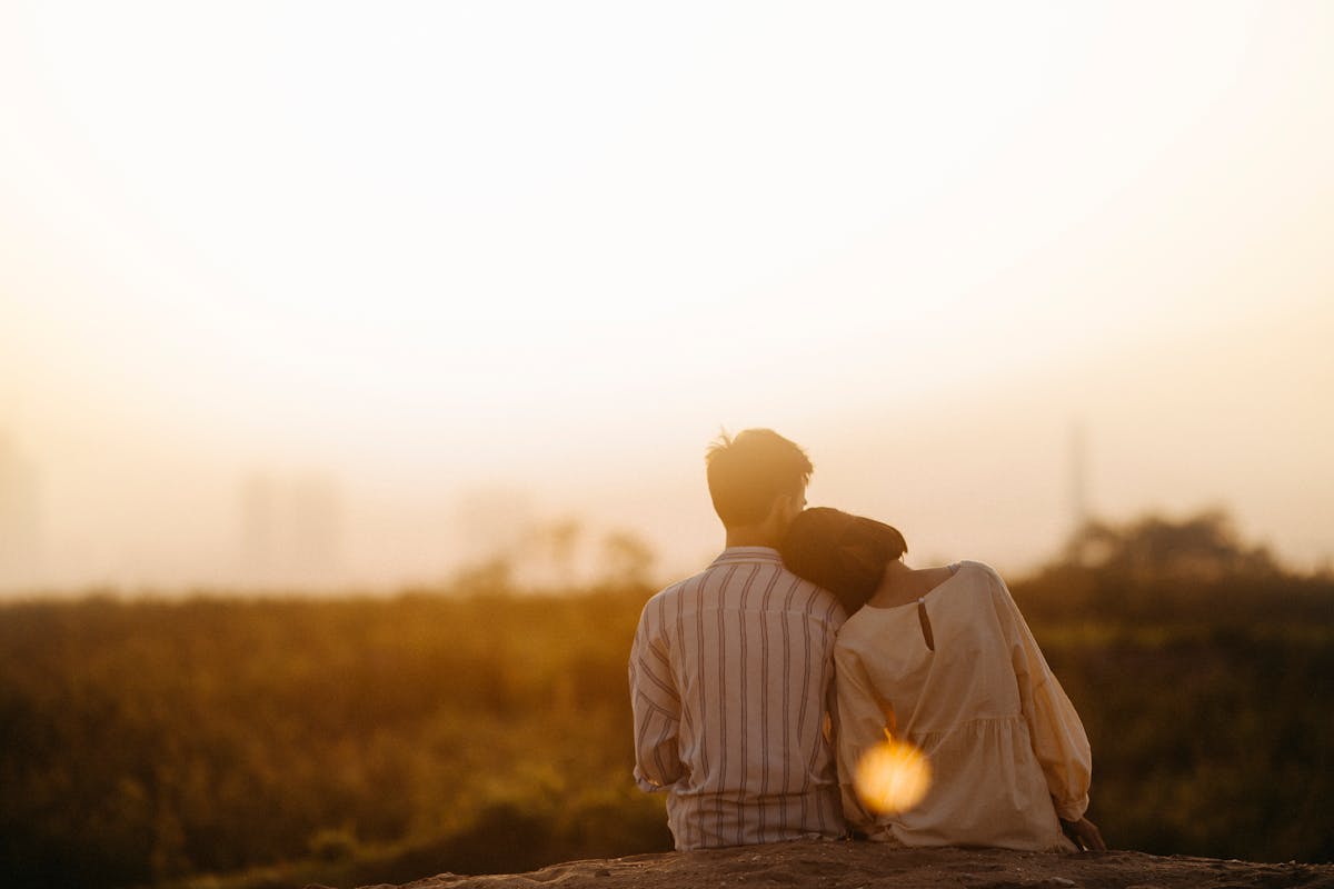 Couple sitting close together at golden hour — hopeful connection