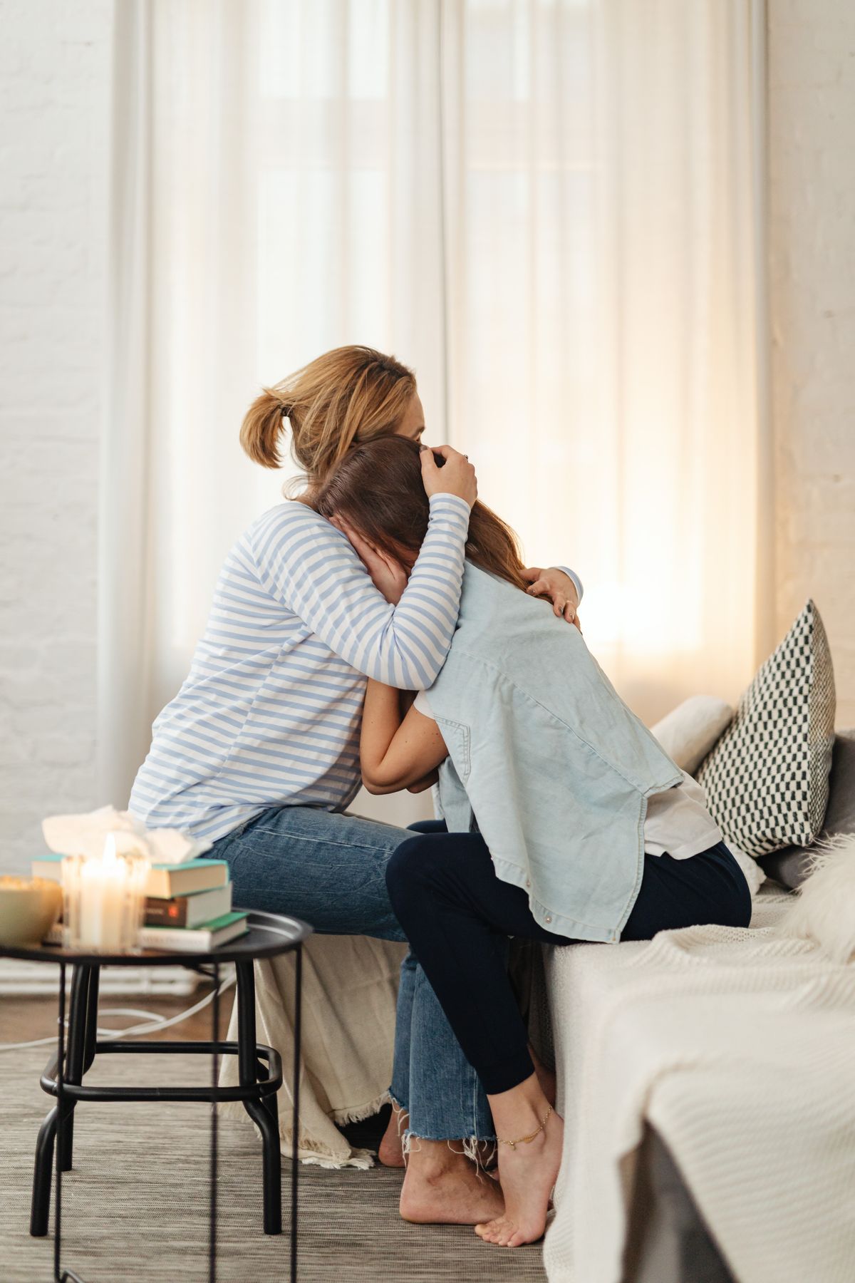 Two people embracing on a sofa in a warm living room, representing the close relationships attachment-based therapy works with