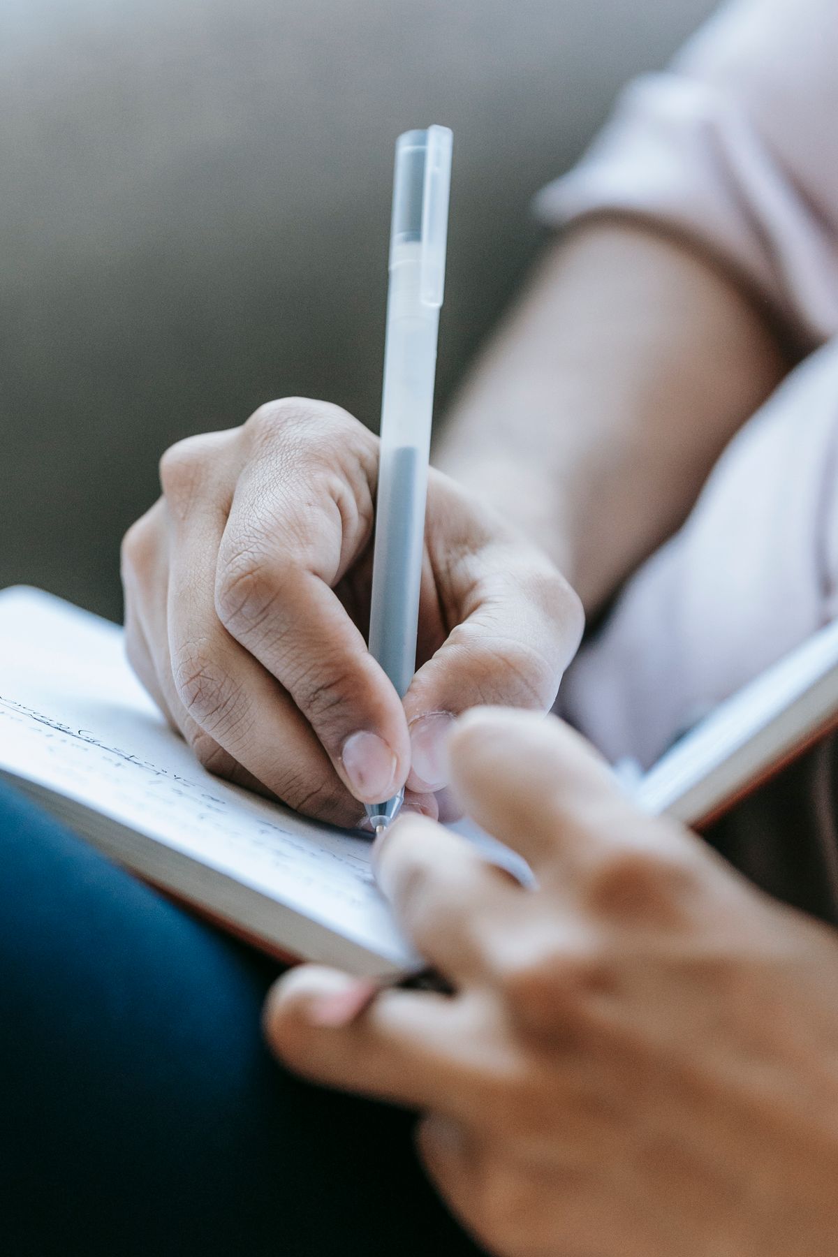 A person writing in a notebook, representing the retelling of your own story in narrative therapy