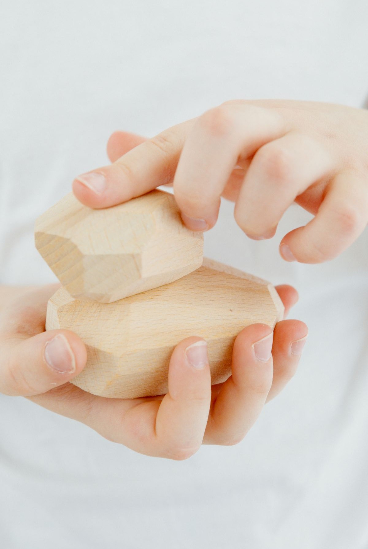 A child's hands holding wooden blocks, representing how play therapy lets children show what they cannot yet say