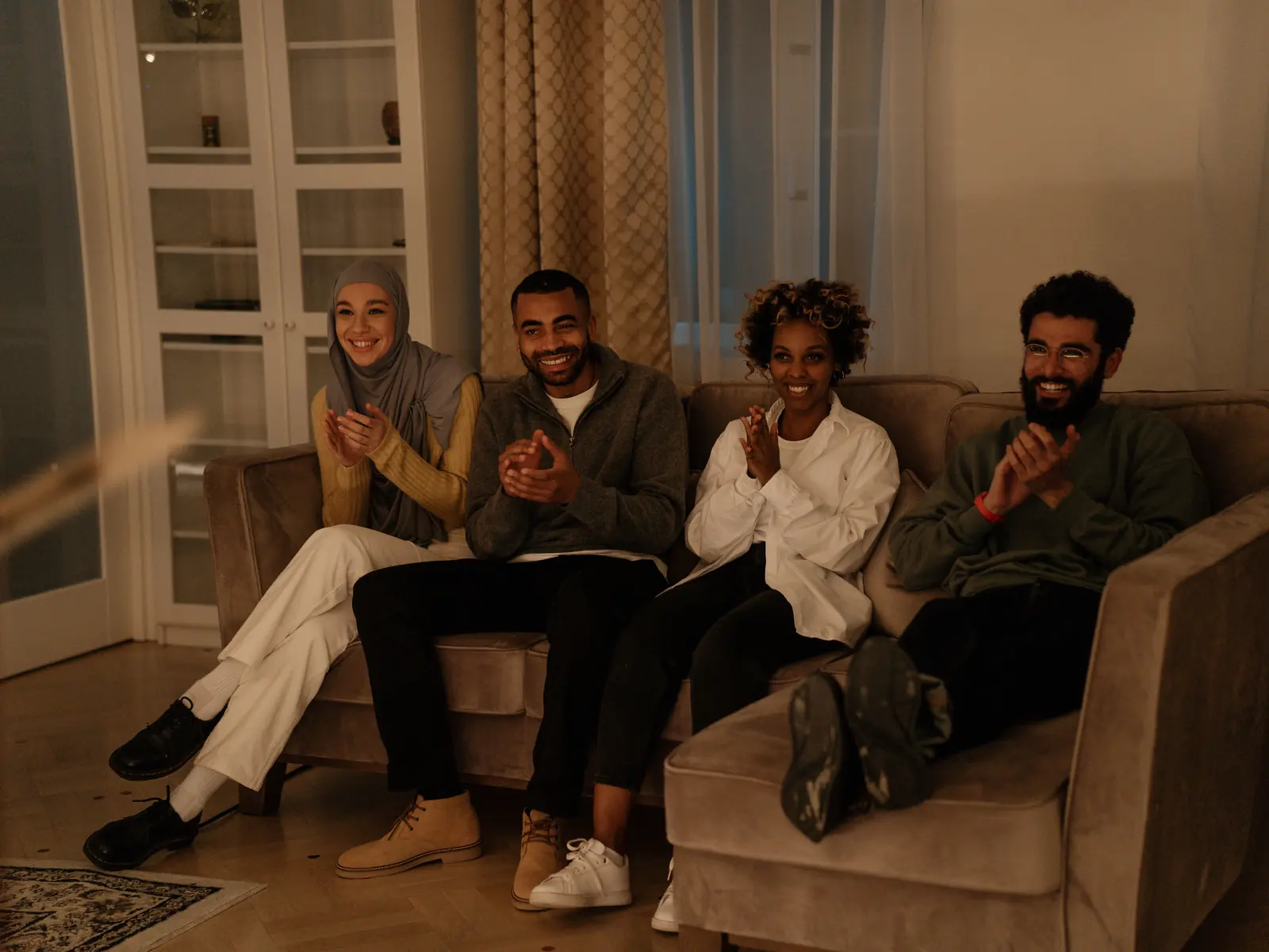 A small group of adults sitting in a circle of armchairs, talking