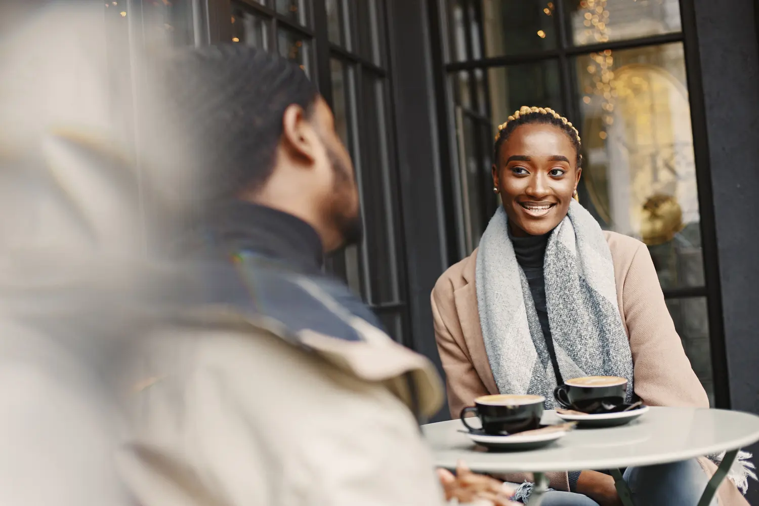 Two people talking together over coffee at a cafe table